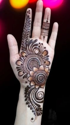 a woman's hand with henna tattoos on it