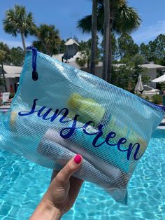 someone is holding up a bag that says sunny screen in front of a swimming pool