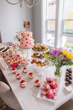 a table topped with lots of different types of cakes and cupcakes on top of it