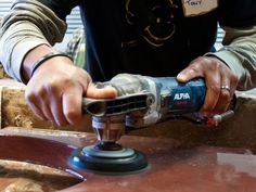 a man sanding wood with a power drill