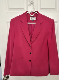 This vintage hot pink blazer features oblong buttons, sewn-in shoulder pads, and buttoned sleeves. Size 12. Condition: Perfect Materials: 100% polyester Measurements:  Pit to pit: 20 inches Shoulder to hem: 25 inches Pink Blazer With Button Closure For Office, Classic Pink Winter Blazer, Pink Single Breasted Button-up Blazer, Pink Button-up Blazer For Office, Pink Single-breasted Button-up Blazer, Pink Button-up Blazer For The Office, Classic Pink Single Breasted Blazer, Classic Pink Single-breasted Blazer, Pink Button-up Outerwear With Single Button