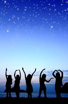 silhouettes of children standing in front of the ocean with their arms up and stars above them