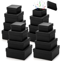 a stack of black boxes with confetti coming out of them