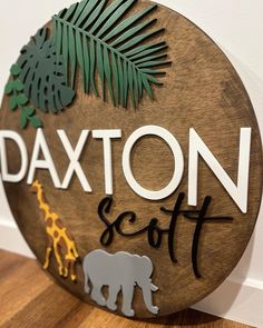 a wooden sign that says, saxon scott with an elephant and giraffe on it