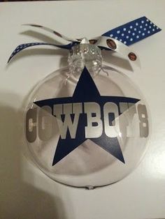 a glass ornament with the word cowboys on it