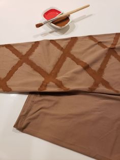 the fabric is brown and has a pattern on it, along with a bowl of dipping sauce