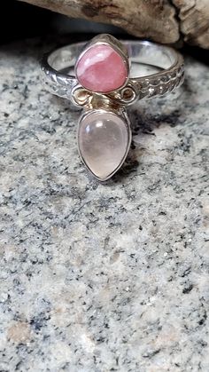 This is a rhodochrosite and rose quartz ring. Rhodochrosite is thought to draw love by opening your heart chakra and rose quartz is thought to promote love, harmony, and peace. They work together to promote love. The front of the ring is 3/4 of an inch tall. It is new unworn old store stock. The ring retailed at $68 and it comes in a jewelry box for gifting. Pink Moonstone Jewelry Gift, Pink Oval Spiritual Ring, Pink Sterling Silver Spiritual Rings, Handmade Pink Moonstone Jewelry, Pink Spiritual Rings For Anniversary, Spiritual Pink Rings For Anniversary, Bohemian Pink Ring For Anniversary, Bohemian Pink Rings For Anniversary, Adjustable Pink Moonstone Ring As Gift