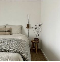 a bedroom with white walls and black and white bedding