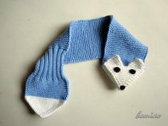 a knitted scarf with a white and blue animal on it