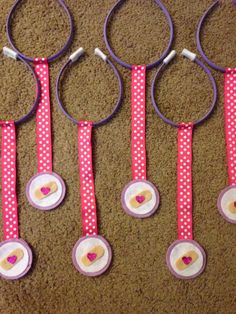 some pink and white scissors are hanging on the wall with polka dot ribbon around them