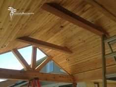 the inside of a house with wooden roofing and wood beams on it's sides