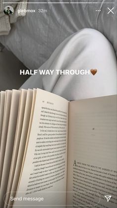 an open book sitting on top of a bed next to white sheets and pillows with the words half way through