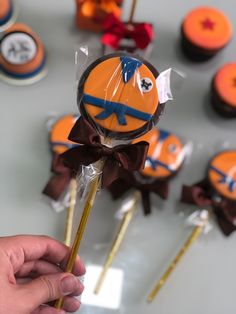 a person is holding up some cupcakes on sticks