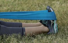 a woman sitting in the grass with her legs crossed