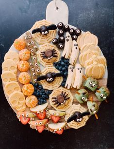 a plate filled with halloween themed cookies and candies on top of a black table