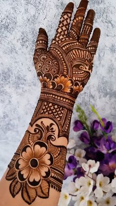 the hand is decorated with henna and flowers