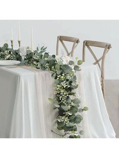 the table is decorated with greenery and candles