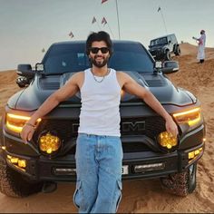 a man standing next to a truck in the desert