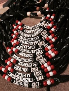 a black, white and red beaded necklace with words on it sitting on top of a table