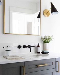 a bathroom sink with a mirror above it and a vase on the counter next to it