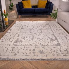 a living room filled with furniture and a rug on top of a hard wood floor