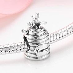 This Sterling Silver Honey Pot Charm is the perfect addition to any jewelry collection. Crafted with 925-grade sterling silver, this charm is an ideal way to show off your love. Show off your unique style with this charmingly detailed charm. Compatible With: Bolenvi Bead Charm Bracelets Bolenvi Moments O Pendants Bolenvi Bead Charm Necklaces Also Compatible: Pandora, Biagi, Troll, Chamilia, Persona, Ohm, Kay's Charmed Memories and similar European Style bead charm bracelets and jewelry. Metal: S Elegant Personalized Sterling Silver Charms, Personalized Sterling Silver Elegant Charms, Sterling Silver Jewelry With Dangling Charms For Anniversary, Symbolic Sterling Silver Charms As Gift, Elegant Sterling Silver Charms For Gifts, Elegant Engraved Sterling Silver Charms, Sterling Silver Jewelry With White Gold Charms, Personalized White Gold Sterling Silver Charms, Sterling Silver White Gold Charms Jewelry