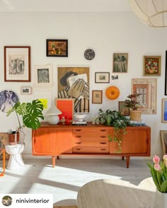 a living room filled with furniture and pictures on the wall