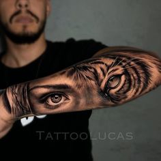 a man's arm with an eye and tiger tattoo on the left side of his arm