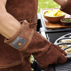 a man in an apron is cooking on the grill with other food items around him