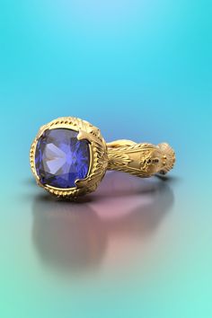 Tanzanite gold ring available in 18k or 14k genuine gold, natural Tanzanite ring designed with a motif inspired by the Italian Renaissance On the shank of the ring the decoration is made with Roman Renaissance elements such as the leaves of Acanthus and the bees of Bernini A beautifully well-crafted elegant ring with natural Tanzanite . A solid gold ring with a combination of raw and polished finishes. All our jewelry are designed by us  and crafted in Vicenza here in Italy, and we really love communicating personally with our customers! Feel free to send us a message  with any questions or customizations! ❥ Details Main stone: Cushion cut Natural Tanzanite from Tanzania Measurements: approx. 7.5x 7.5x 4.5mm approx. 1,9 / 2 Cts Sizes available: choose your size from the drop down menu ❥ Sh Elegant Gold Tanzanite Rings, Elegant Gold Rings With Tanzanite, Gold Tanzanite Birthstone Ring For Formal Events, Gold Tanzanite Birthstone Ring For Formal Occasions, Elegant Gold Amethyst Ring With Intricate Design, Ring Sculpture, December Birthstone Ring, Tanzanite Ring, Black Gift Boxes