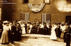 an old black and white photo of people in front of a building with american flags