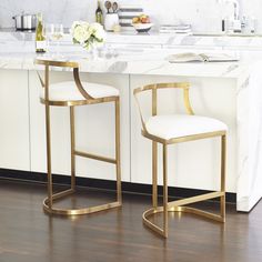 two white and gold bar stools in a kitchen