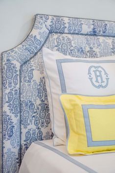 a blue and white bed with yellow pillows