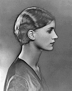 an old black and white photo of a woman's profile with her hair in a bun