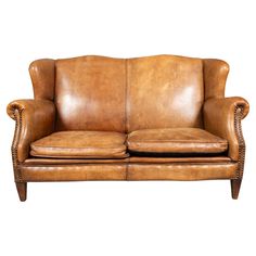 a brown leather couch sitting on top of a white background