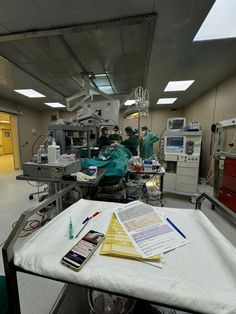 an operating room filled with medical equipment and people in scrubs working on the machines