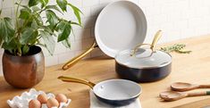 an assortment of kitchen utensils sitting on a counter top next to a potted plant