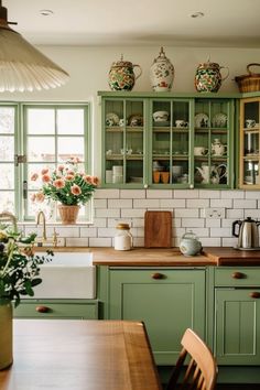 a kitchen filled with green cabinets and wooden counter tops