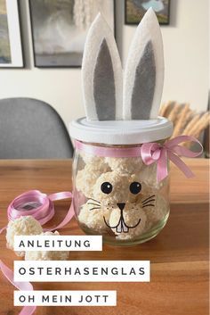 an easter decoration in a jar with bunny ears and rice krispy treats on the table