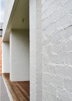 a white brick building with wood flooring next to it