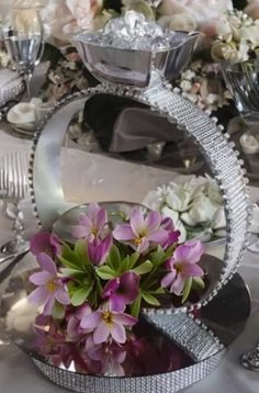 the table is set with flowers and silverware