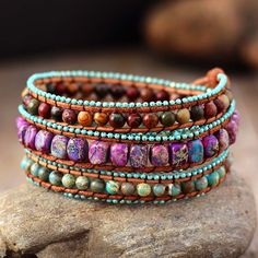 This Handmade Mixed Jasper Bohemian Vintage Leather Wrap Bracelet is a unique and stylish accessory that combines the natural beauty of mixed Jasper stones with a vintage leather design. The bracelet features a variety of different Jasper stones, each with its own unique pattern and color. Jasper is a grounding stone that is said to bring stability and balance to the wearer. It is also believed to have a calming effect and to help with emotional healing. The leather strap of this bracelet is des Multicolor Beaded Leather Jewelry, Bohemian Wrap Bracelet With Gemstone Beads For Festivals, Bohemian Gemstone Beads Wrap Bracelet For Festivals, Bohemian Brown Beaded Bracelets With Gemstones, Bohemian Leather Beaded Bracelet For Healing, Brown Natural Stone Wrap Bracelet For Festivals, Bohemian Brown Beaded Gemstone Bracelets, Festival Brown Wrap Bracelet With Natural Stones, Bohemian Brown Gemstone Beaded Bracelets