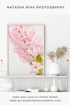 a white shelf topped with pink flowers and vases