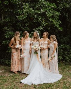 the bride and her bridesmaids are posing for a photo in front of some trees