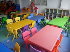 a classroom filled with lots of colorful tables and chairs