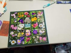 a table topped with lots of different types of flowers next to markers and pencils