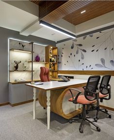 an office with a desk and chairs in the middle, along with a wall mural behind it