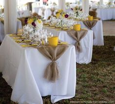 the tables are set up with white linens and yellow napkins