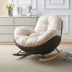 a white rocking chair sitting on top of a carpeted floor