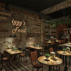 the interior of a restaurant with wooden tables, chairs and lights on the brick wall